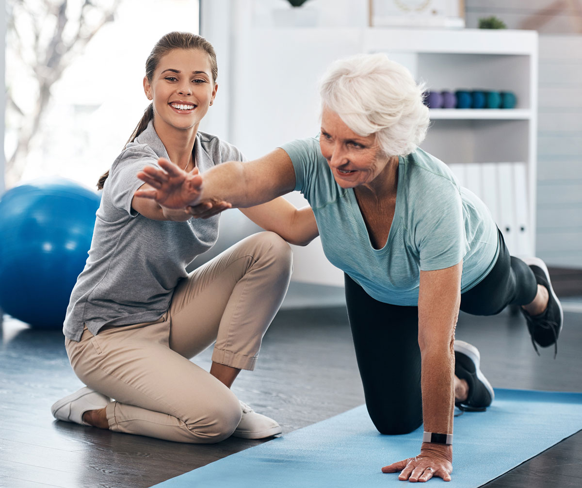 Woman exercising with personal trainer or physical therapist