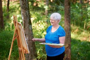 Senior woman painting outside at Rolling Green Village