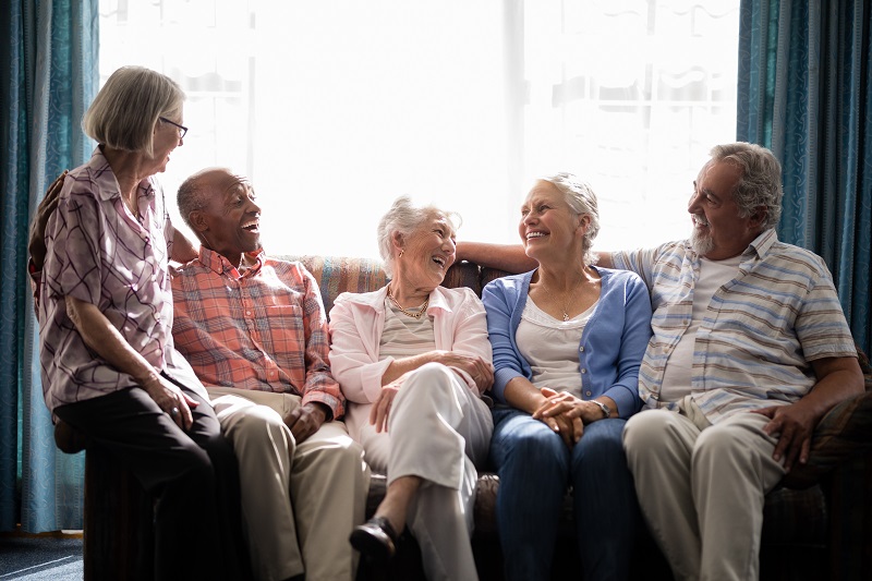 a group of seniors enjoying social time on a couch at a independent living community