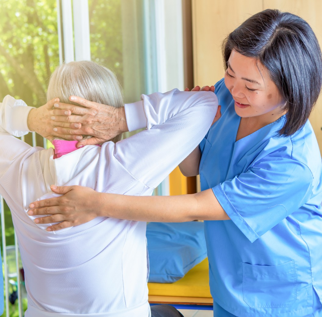 Female physical therapist helping senior woman in rehab