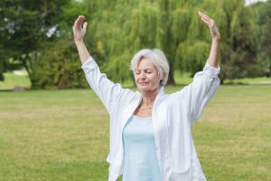 senior fitness tips woman doing tai chi outside