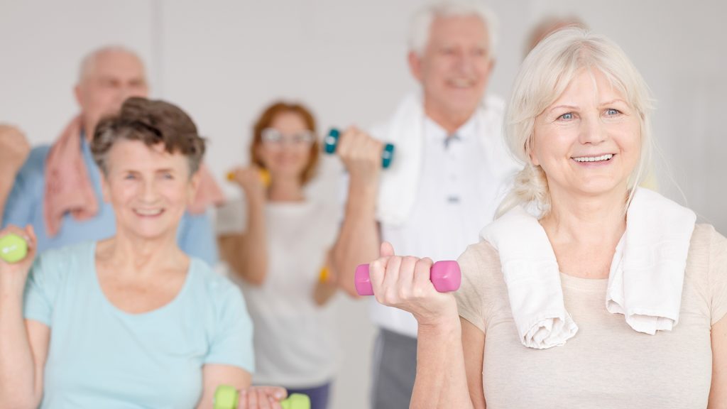 seniors in a fitness class lifting weights