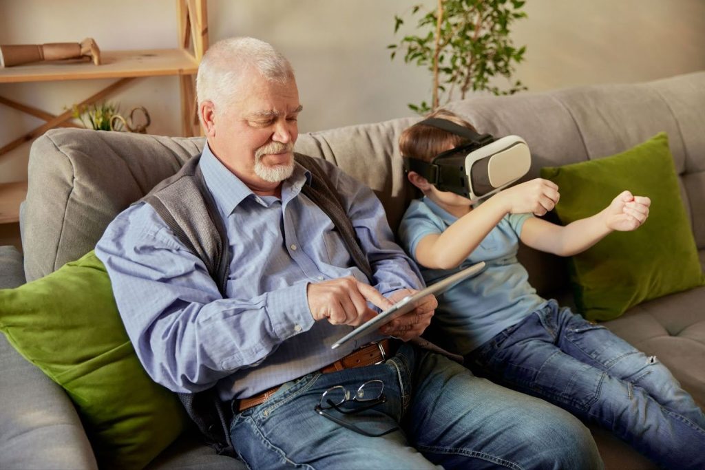 Senior playing virtual reality with his grandson.