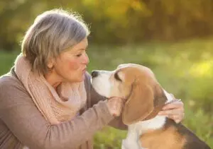 senior woman with pet beagle dog outside