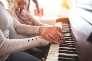 elderly woman and younger woman playing piano together