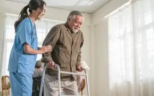 female nurse care giver helping senior old man