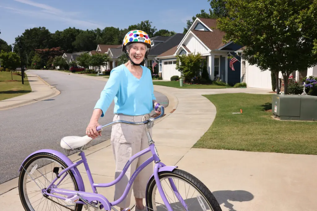 Active older adult riding a bike in the independent living neighborhood at Rolling Green Village