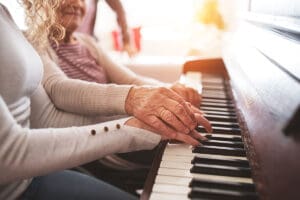 elderly woman and younger woman playing piano together