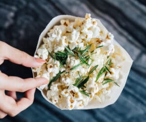 hand reaching into popcorn bowl
