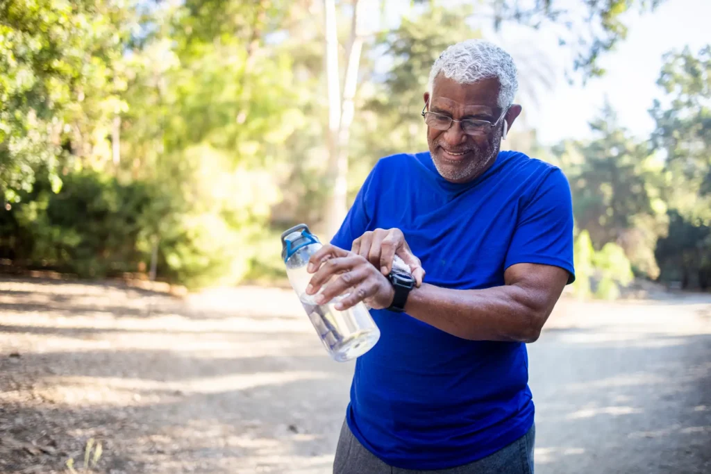 senior man using an apple watch outside exercising