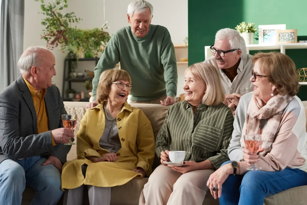 A group of seniors relax and laugh over coffee and wine at Rolling Green Village in Greenville, SC.