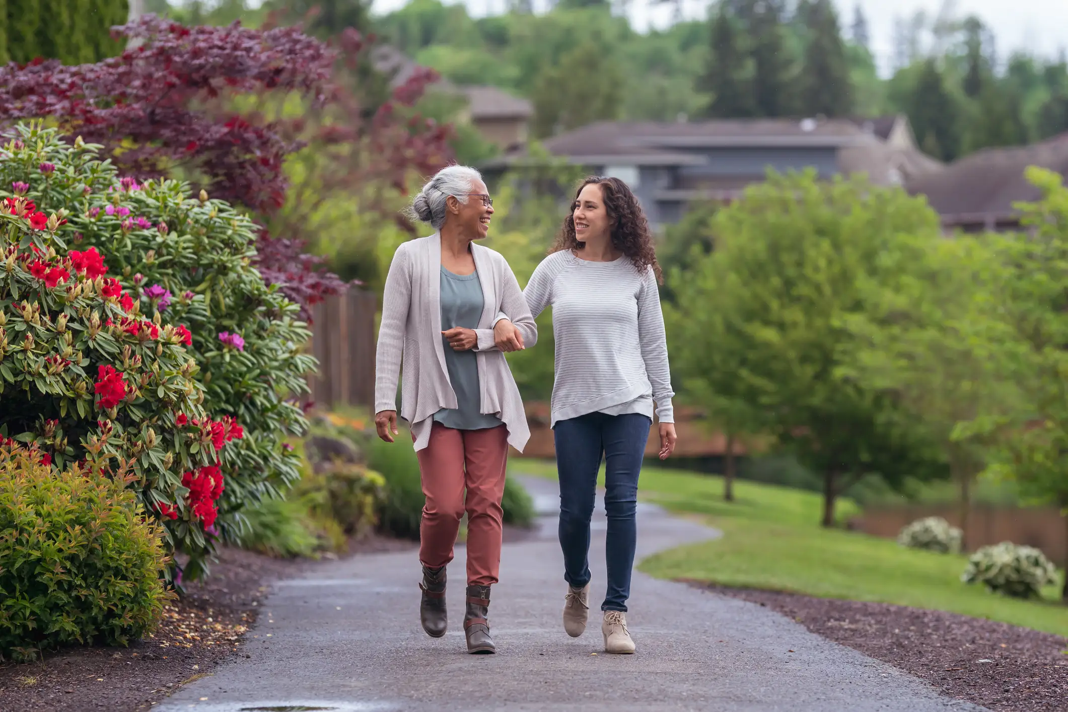 A senior woman and her adult daughter walking on a trail outside of Rolling Green Village, a non-profit senior living community in Greenville, SC.